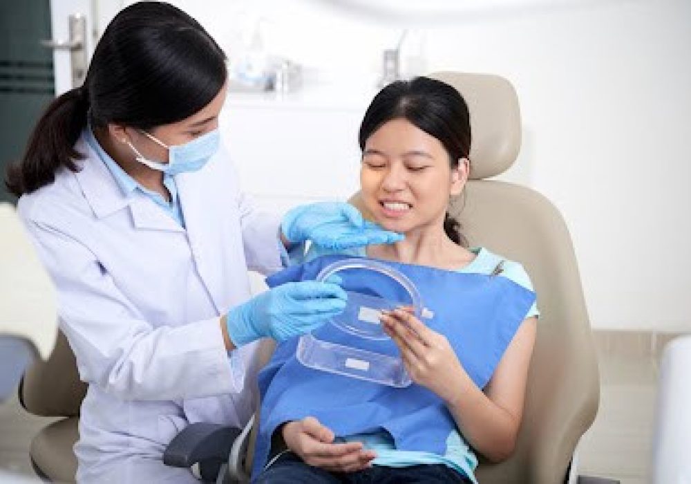 Doctor giving her patient mirror so she can look at her new smile